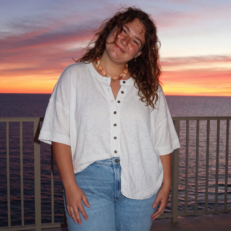Woman in a white relaxed top at sunset